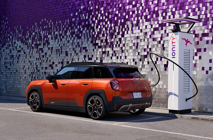 Vollelektrischer MINI Cooper an IONITY Ladesäule Vollelektrischer MINI Cooper Seitenansicht an IONITY Ladesäule